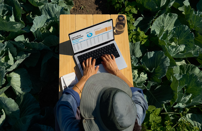 Eine Person nützt im Freien ein MacBook Pro mit dem Display mit Nanotextur-Option und zeigt, wie Blendeffekte reduziert werden